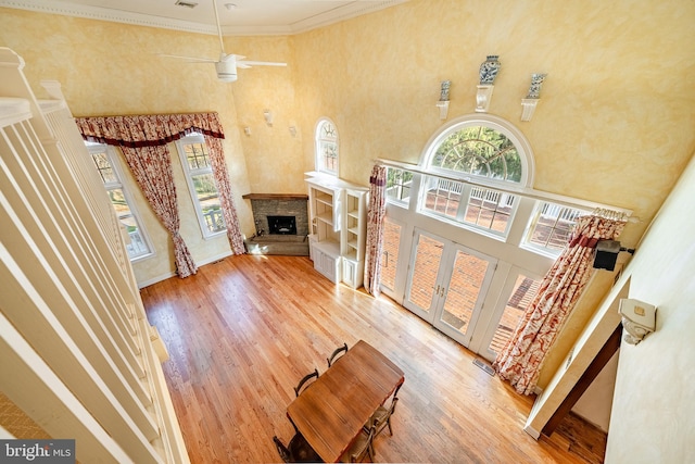 entrance foyer with hardwood / wood-style flooring, ceiling fan, crown molding, and a high ceiling