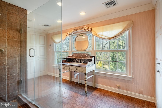 bathroom featuring vanity, a shower with shower door, and ornamental molding