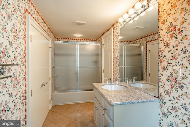 bathroom with tile patterned floors, vanity, and bath / shower combo with glass door