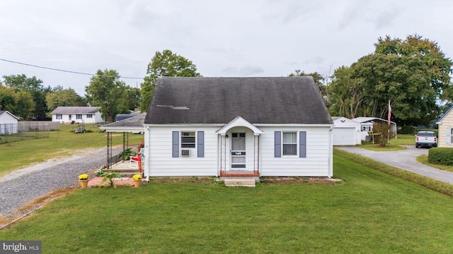 view of front of property featuring a front yard and a storage shed