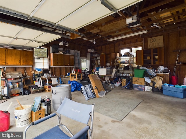 garage with a garage door opener and wood walls