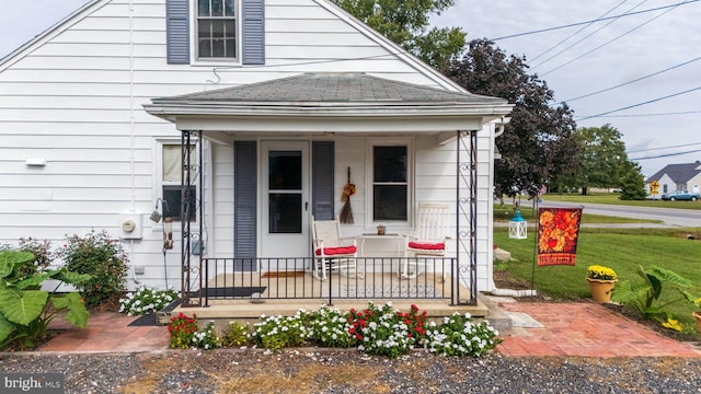 property entrance with covered porch and a yard