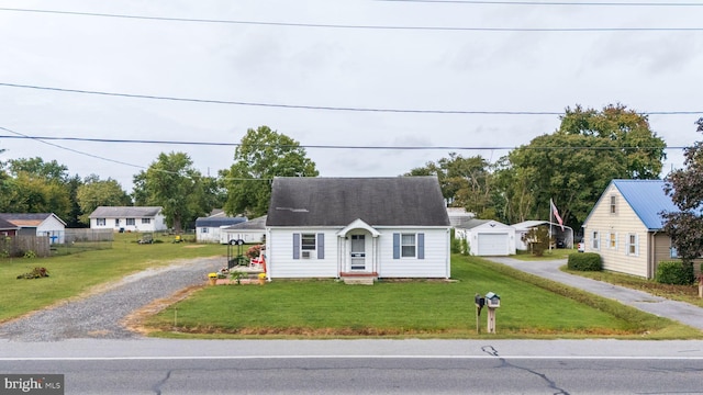 cape cod home with an outdoor structure, a garage, and a front lawn