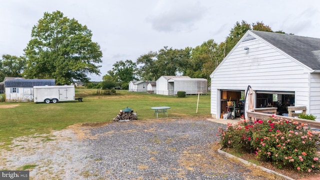 view of yard with a garage and an outbuilding