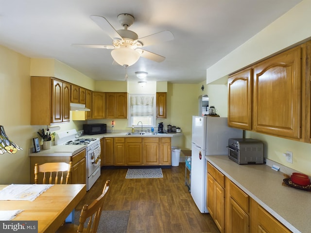 kitchen featuring white appliances, ceiling fan, sink, and dark hardwood / wood-style flooring