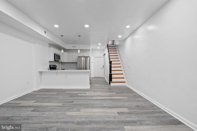 unfurnished living room with light wood-type flooring and sink