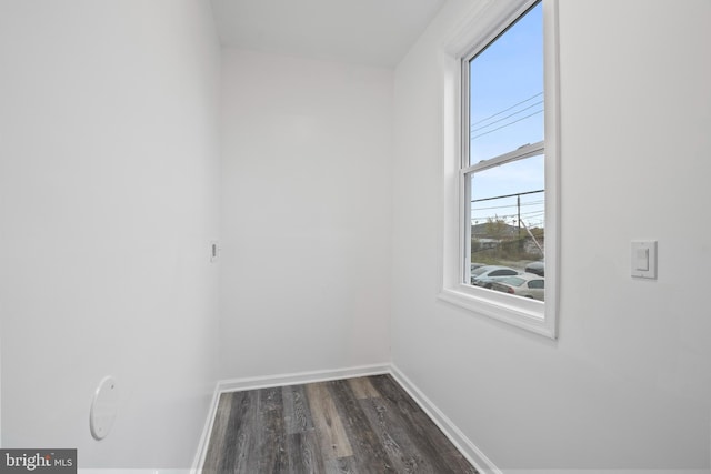 empty room featuring a healthy amount of sunlight and dark hardwood / wood-style floors