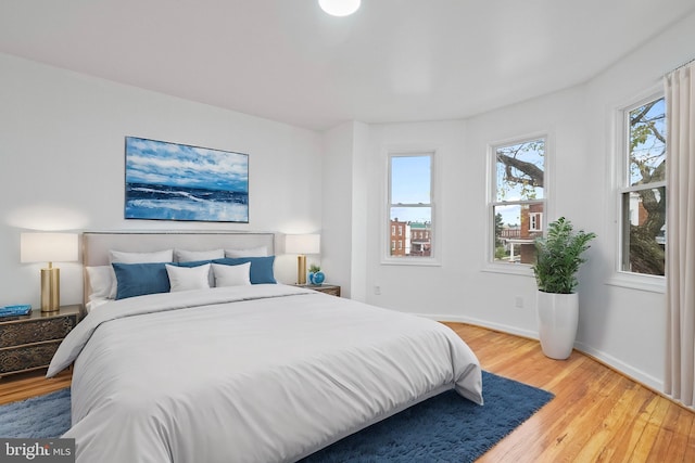 bedroom featuring wood-type flooring and multiple windows