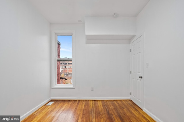 unfurnished room with wood-type flooring