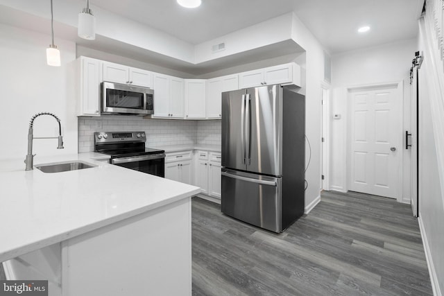 kitchen with pendant lighting, stainless steel appliances, white cabinetry, and sink