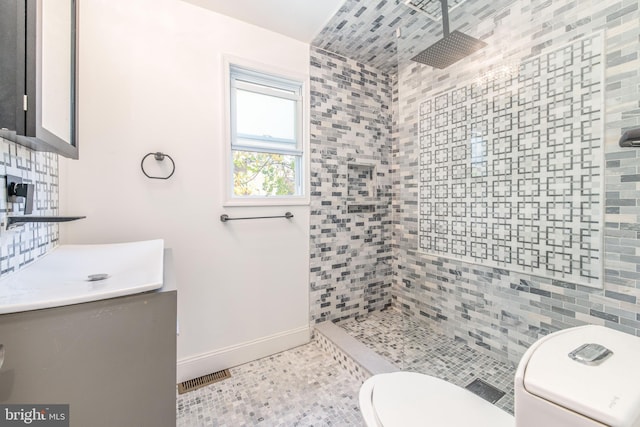 bathroom featuring backsplash, a tile shower, tile walls, toilet, and vanity