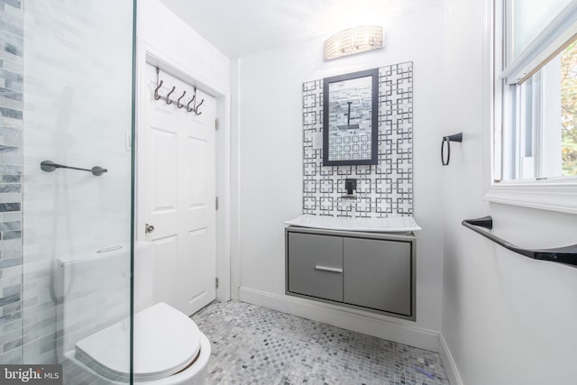 bathroom with vanity, toilet, and a shower with door