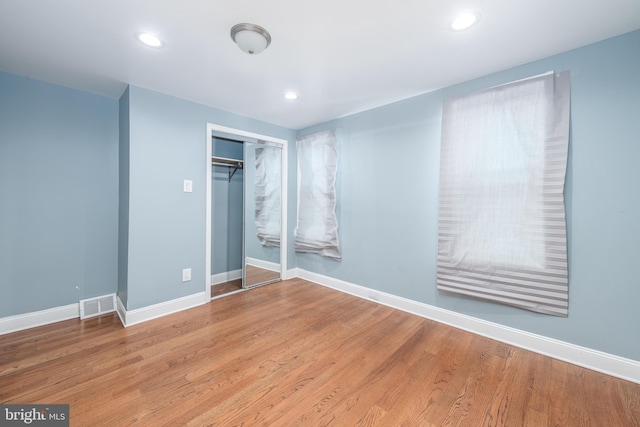 unfurnished bedroom featuring a closet and hardwood / wood-style floors