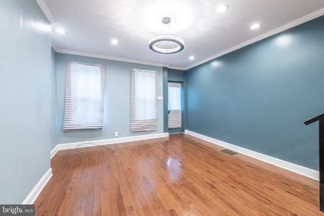 unfurnished room featuring hardwood / wood-style floors and crown molding