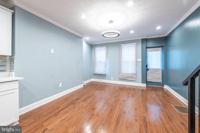 spare room featuring light hardwood / wood-style floors and crown molding