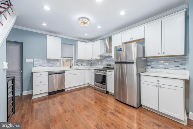 kitchen featuring white cabinetry, wall chimney range hood, stainless steel appliances, and hardwood / wood-style flooring