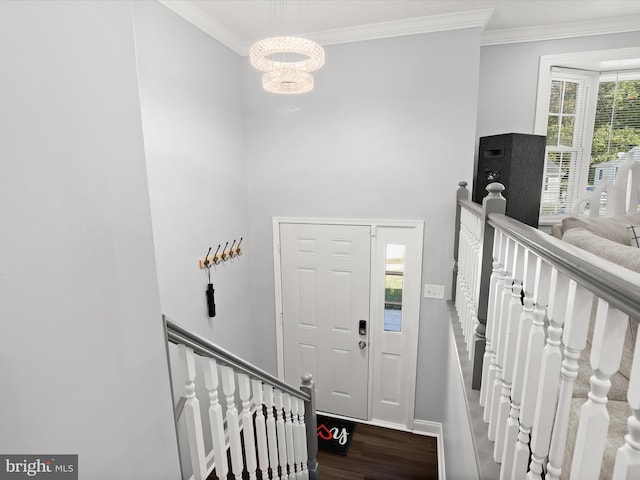 entryway featuring an inviting chandelier, ornamental molding, and hardwood / wood-style flooring