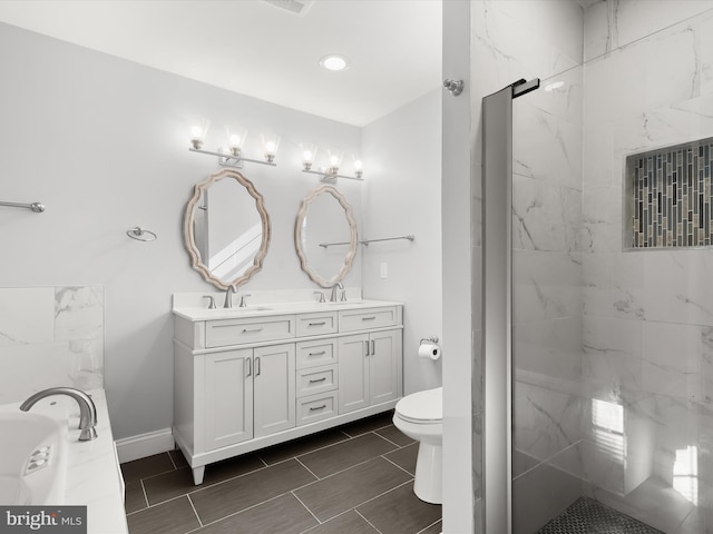 bathroom with vanity, toilet, and tiled shower