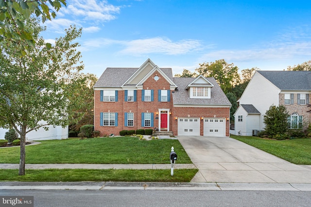 colonial house featuring a garage and a front lawn