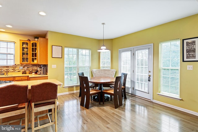 dining room featuring light wood-type flooring, a healthy amount of sunlight, and sink