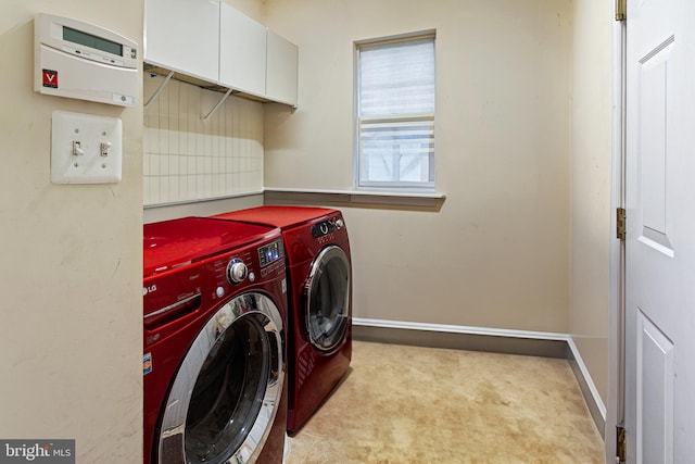 laundry room with washer and clothes dryer, cabinets, and light carpet