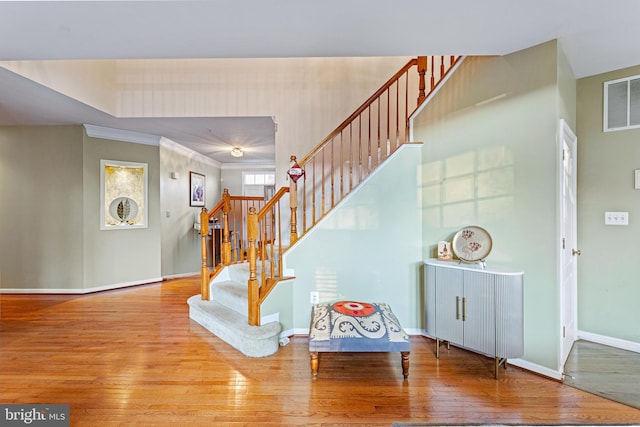 interior space with ornamental molding and hardwood / wood-style floors