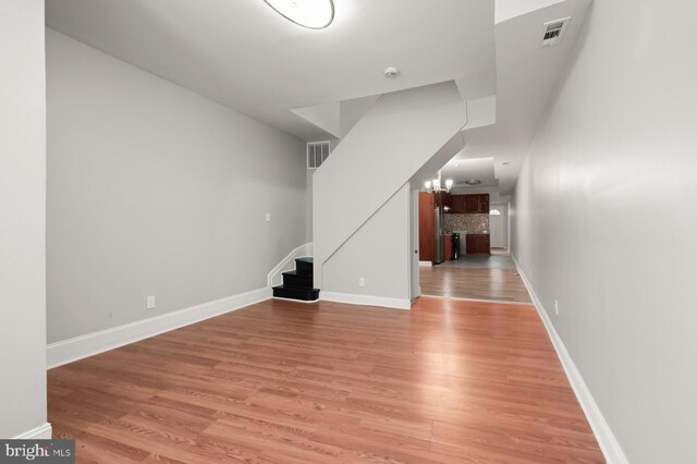 2333 Mcculloh St, Baltimore, MD 21217 - unfurnished living room with wood-type flooring and an inviting chandelier