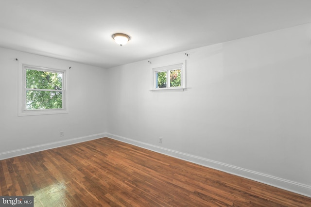 unfurnished room featuring dark hardwood / wood-style floors and a healthy amount of sunlight