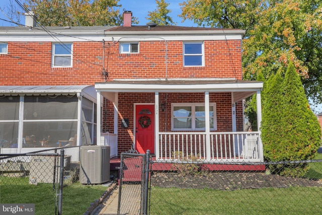 view of front of property featuring a sunroom, central AC, a porch, and a front lawn