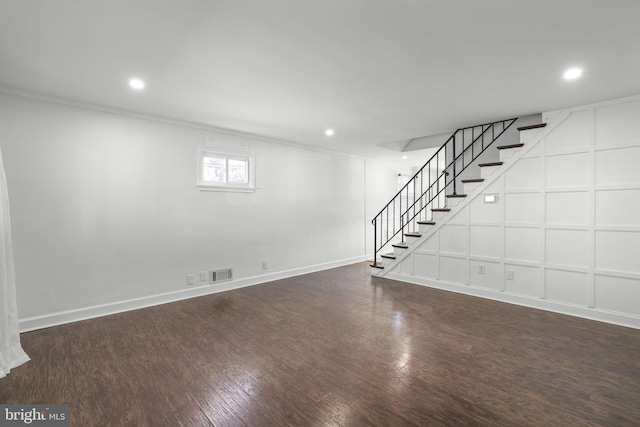 basement with ornamental molding and dark hardwood / wood-style floors