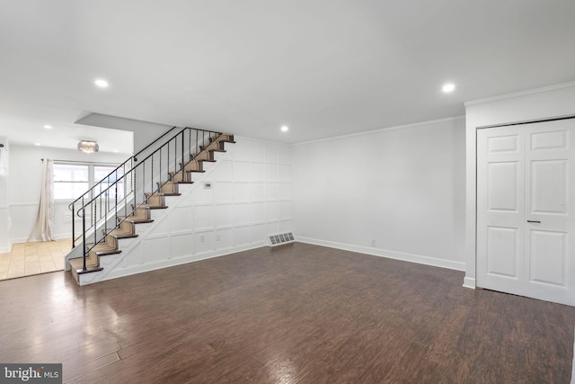 basement featuring dark wood-type flooring and crown molding