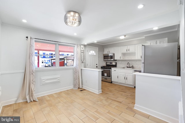 kitchen featuring sink, light wood-type flooring, white cabinetry, stainless steel appliances, and decorative backsplash