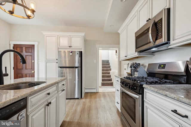 kitchen with light hardwood / wood-style floors, sink, a notable chandelier, white cabinetry, and stainless steel appliances