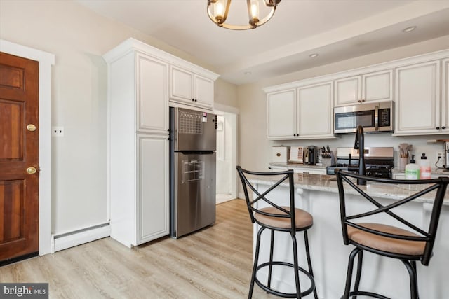 kitchen featuring light hardwood / wood-style floors, white cabinetry, stainless steel appliances, a baseboard radiator, and a chandelier