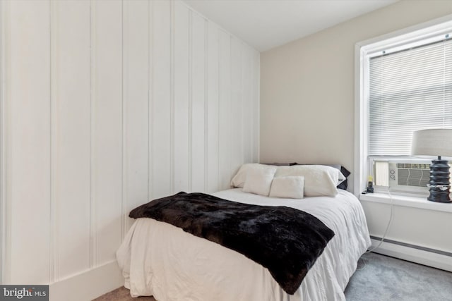 bedroom featuring light carpet and a baseboard heating unit