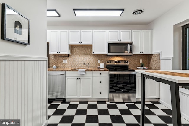 kitchen with white cabinets, appliances with stainless steel finishes, tasteful backsplash, and sink