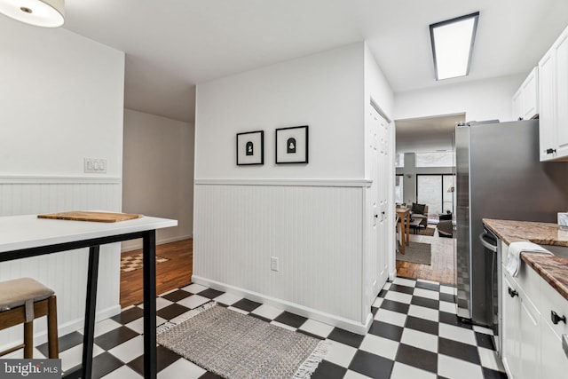 kitchen featuring dishwasher, dark hardwood / wood-style flooring, and white cabinetry