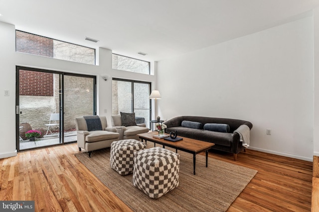 living room featuring light hardwood / wood-style floors and a towering ceiling