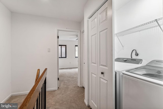 laundry area featuring ceiling fan, light colored carpet, and washing machine and clothes dryer