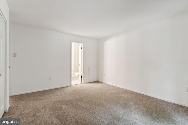 interior space featuring ensuite bathroom and carpet