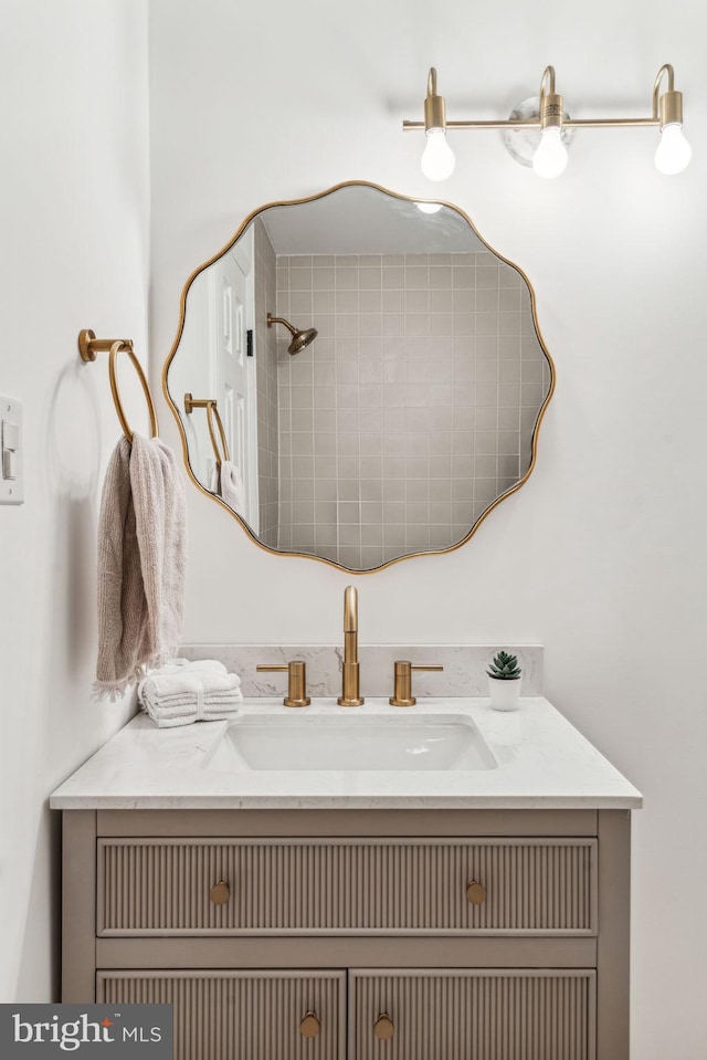 bathroom featuring a shower and vanity