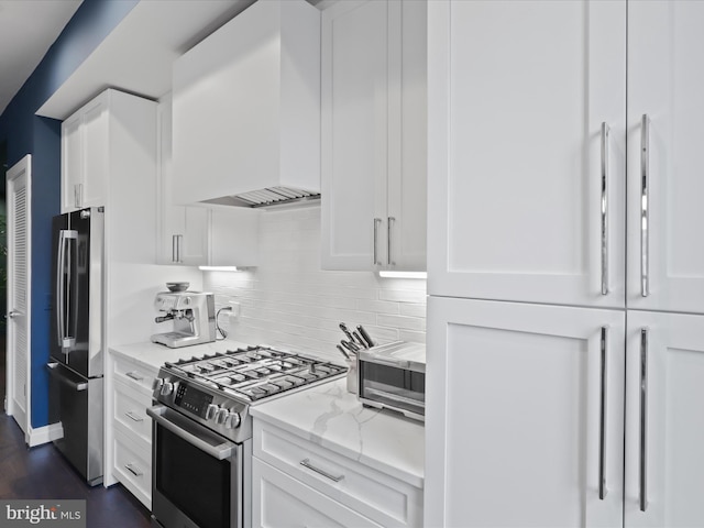 kitchen with light stone countertops, appliances with stainless steel finishes, and white cabinetry