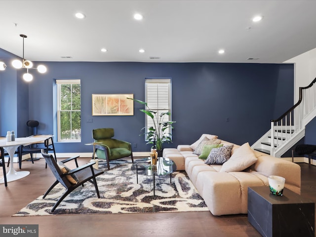 living room featuring an inviting chandelier and dark wood-type flooring