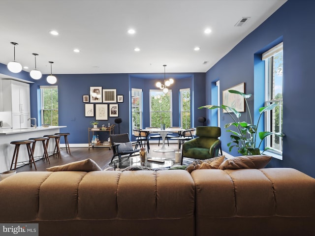 living room featuring a notable chandelier and dark hardwood / wood-style flooring