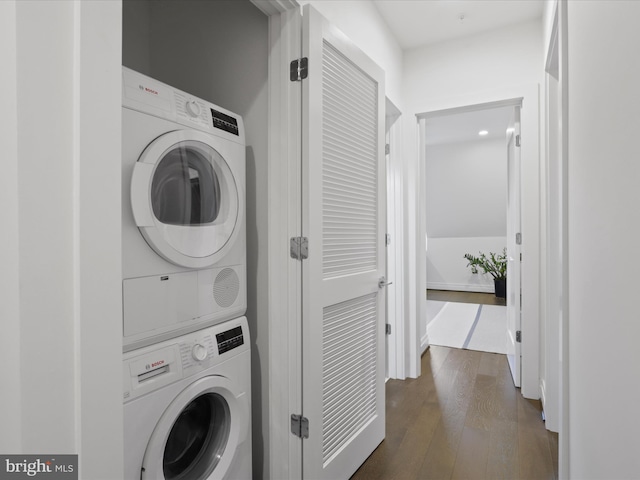 washroom with dark hardwood / wood-style floors and stacked washer and dryer