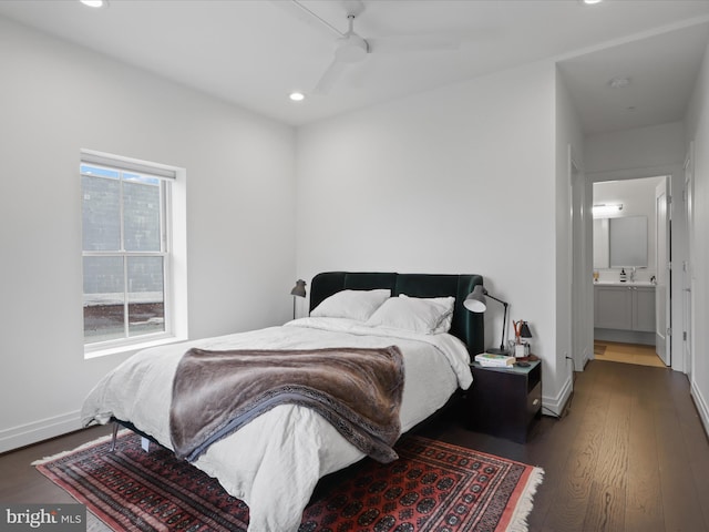 bedroom with ceiling fan, connected bathroom, and dark hardwood / wood-style flooring