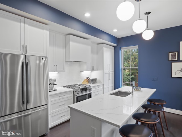 kitchen featuring white cabinetry, appliances with stainless steel finishes, hanging light fixtures, and sink