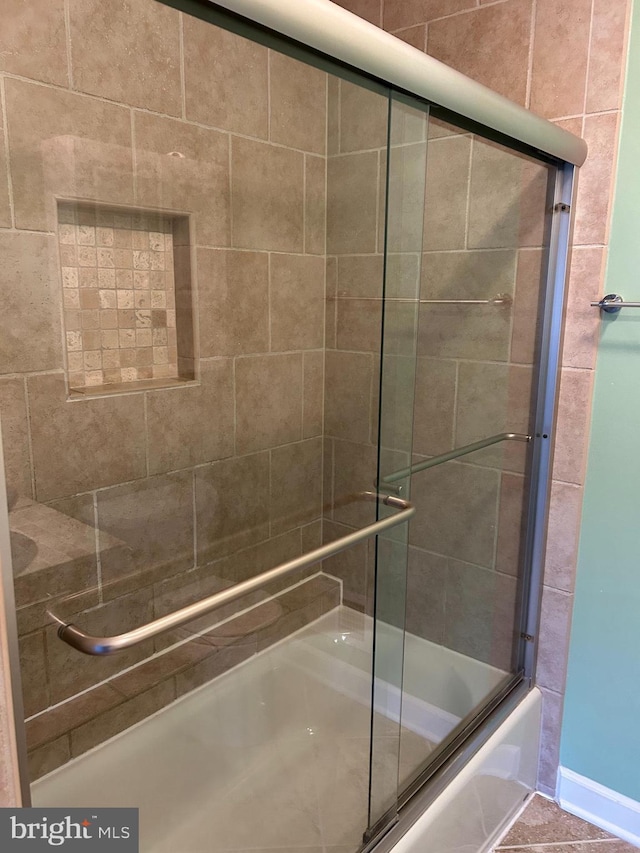 bathroom with combined bath / shower with glass door