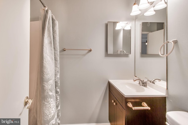 full bathroom featuring a shower with shower curtain, vanity, and toilet