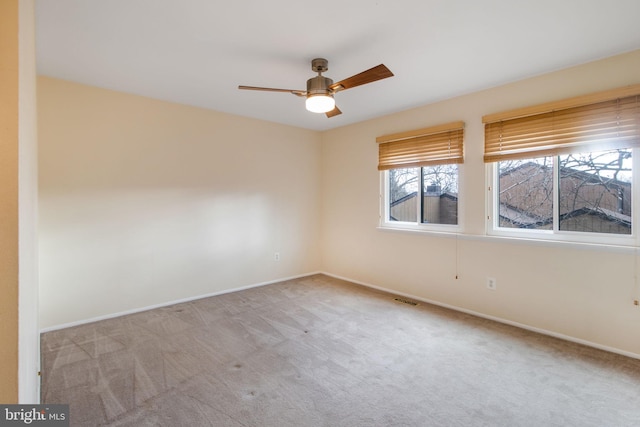 empty room with baseboards, carpet flooring, visible vents, and a ceiling fan